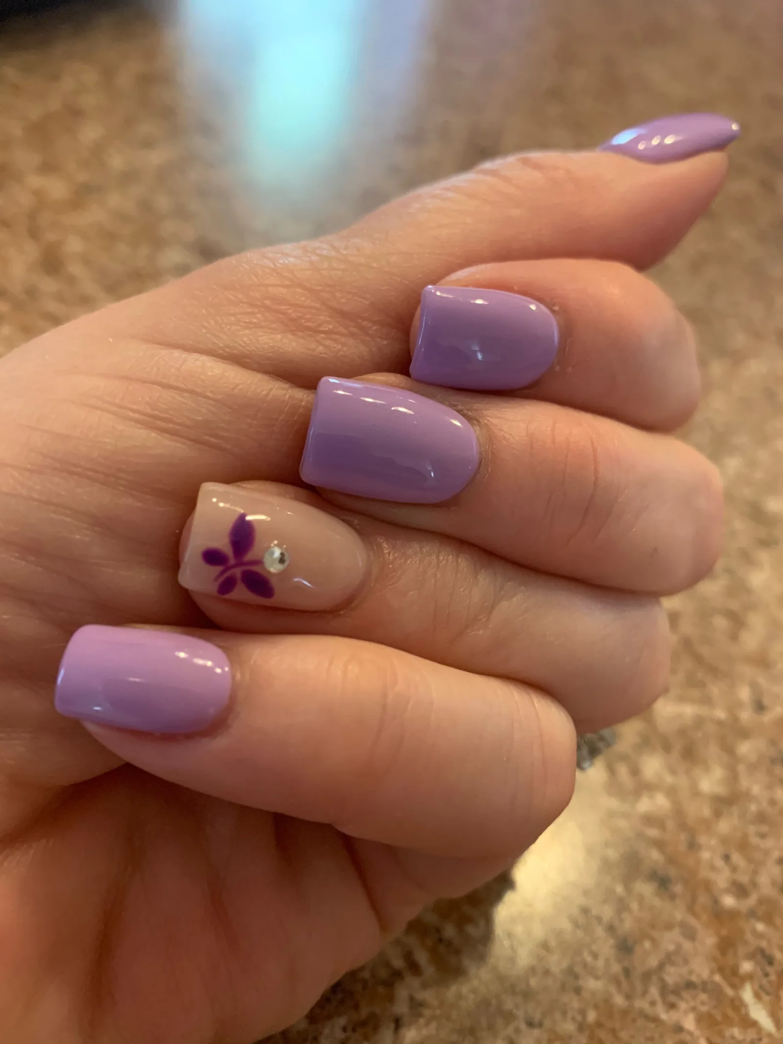 Manicure for acrylic nails with lavender polish and design using crystal