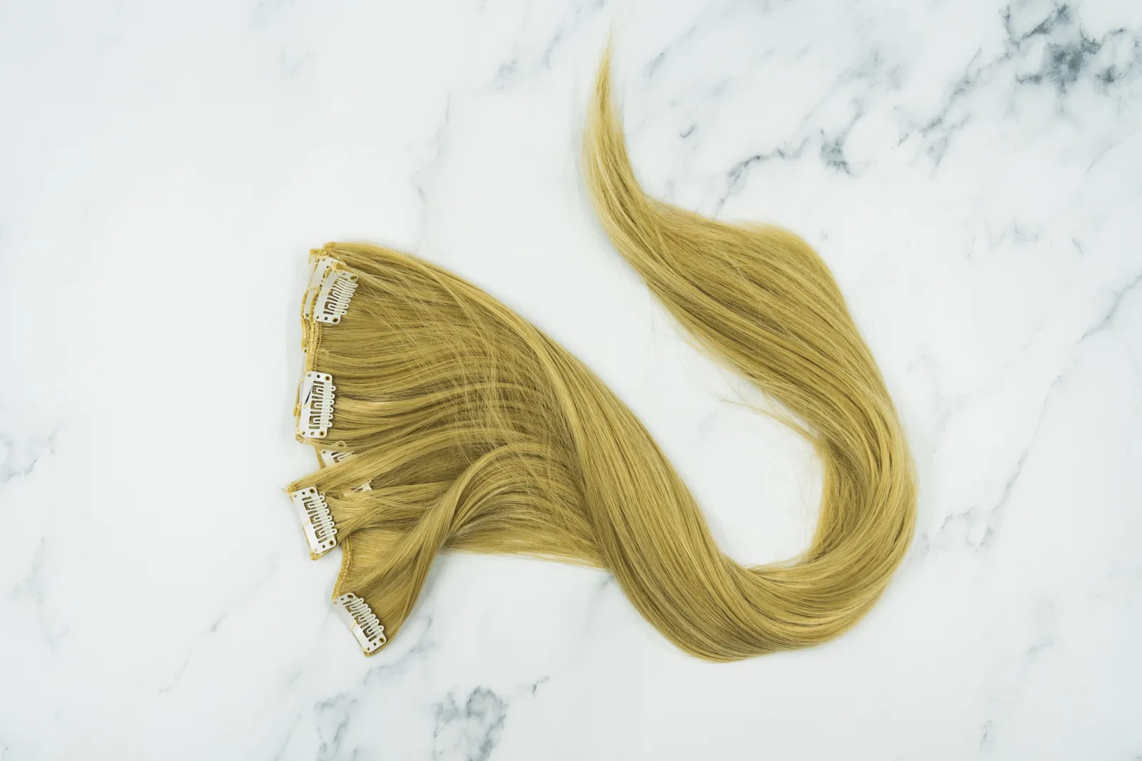 This photograph shows a full set of blonde, clip-in hair extensions. We originally took this photograph to use in a blogpost about 100% natural, remy hair extensions, but have since decided to release it under Creative Commons for anyone to use! Please feel free to use this image in any way you wish, but remember to credit us when you do so, in the form of a link to our website geehair.com/