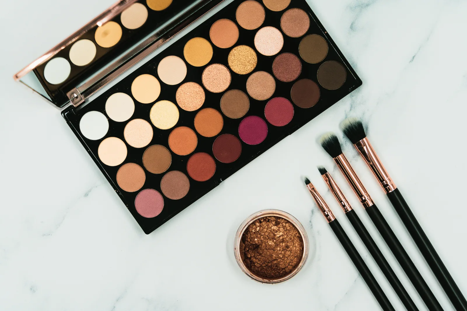 A large eye shadow palette can be seen in this image, alongside a range of make up brushes and a shimmery pot of bronzer. This image was initially taken for an article on the best hair and beauty tips, but we'd now like to share it with you by releasing it under Creative Commons. You may use this image in way you like - but don't forget to credit us by linking back to our website geehair.com/