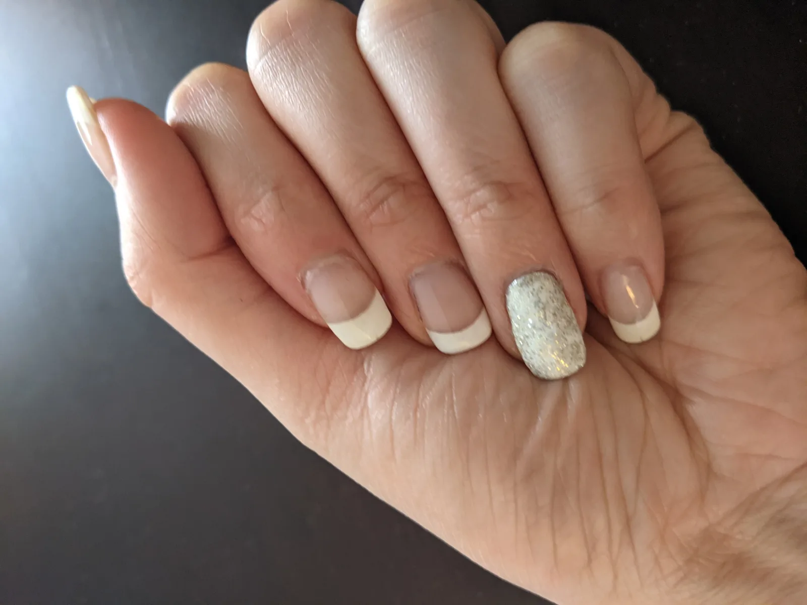 French Manicure with Glitter nail art on ring finger.