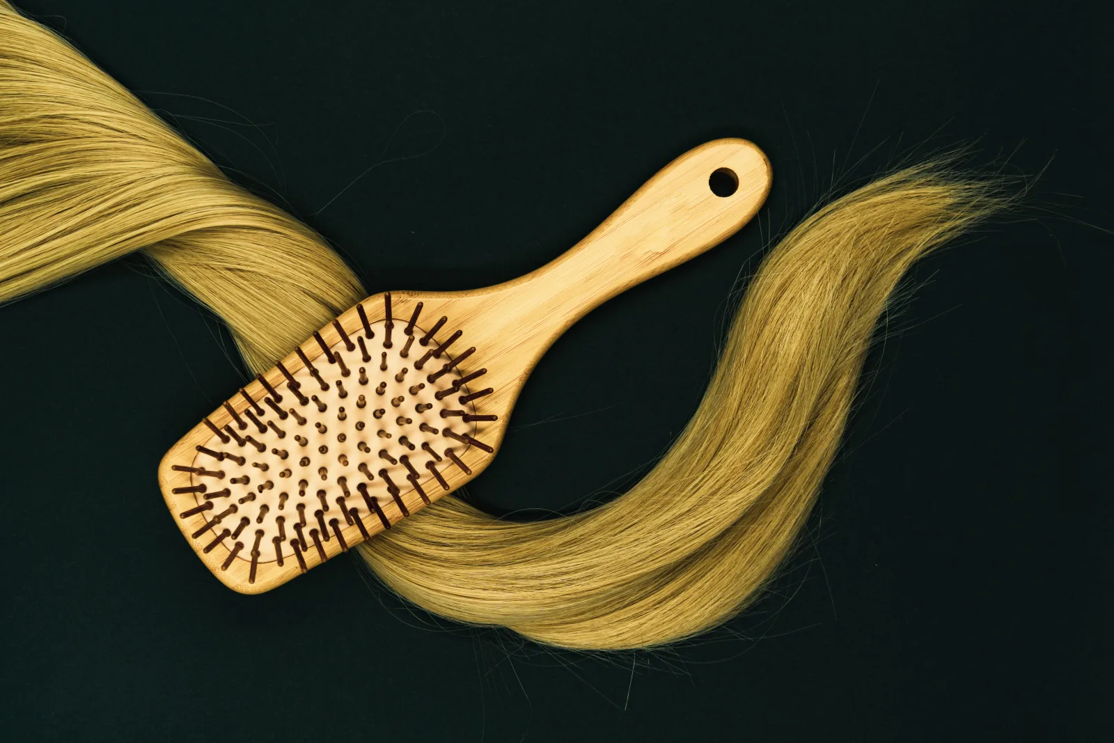 In the photograph a hair brush and a long lock of blonde hair can be seen. We created this image for a piece we wrote on how to style long hair, but have since decided to release it under Creative Commons to share it with you! Please feel free to use it for any purpose, but make sure you credit us when you do so in the form of a link to geehair.com/