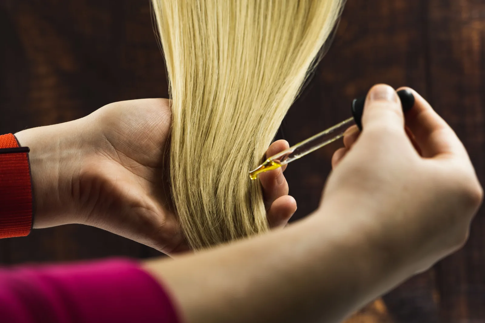 In this photo, a hairdresser can be seen applying hair oil to moisturise a person's hair during their treatment. We initially created this image for our own use, but have now chosen to release it under Creative Commons Attribution Licensing. This means we're more than happy for you to use it, but ask that you please include appropriate credit by including a link to our website geehair.com/