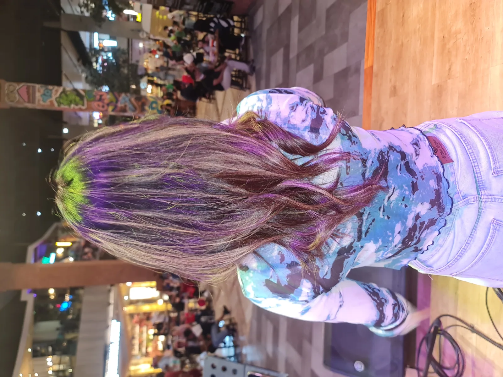 Woman with long, light brown hair from behind. Her name is Arinda Sundana, an Indonesian singer from Surabaya who joined the audition of 10th season of Indonesian Idol but failed. She is now a vocalist of a local band called Warna Hijau (means Green Color in Indonesian). Photographed while performing at Food Society, Pakuwon Mall in West Surabaya, East Java, Indonesia.