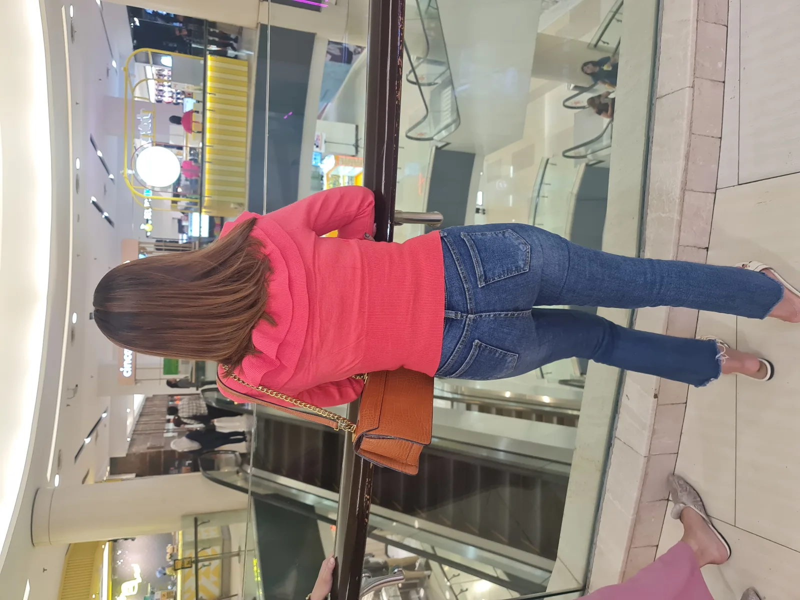 Women with medium-length brown hair from behind. Photographed at Tunjungan Plaza in Central Surabaya, East Java, Indonesia.