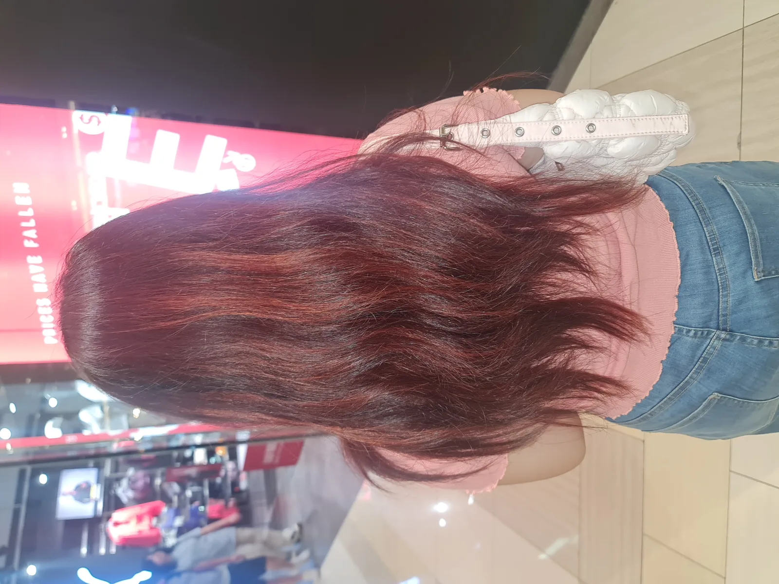 Young woman with long red hair from behind