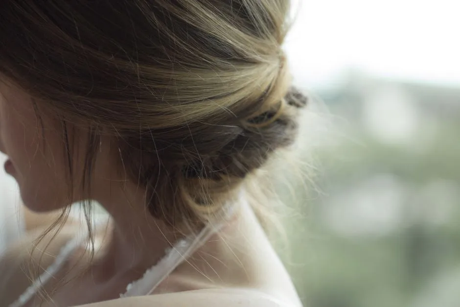 Close-up of elegant blonde updo hairstyle on a woman indoors.