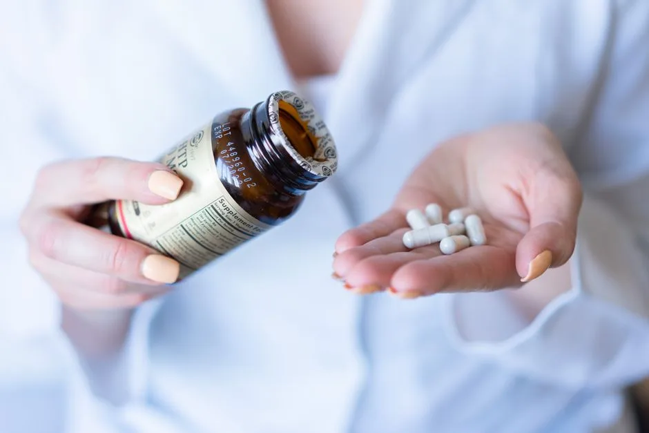 A close-up shot of hands holding a medicine bottle and pills, with a focus on healthcare and medication usage.