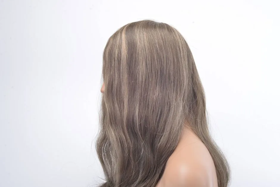 Profile view of a woman's head wearing a long, wavy hairpiece, showcasing hair detail.