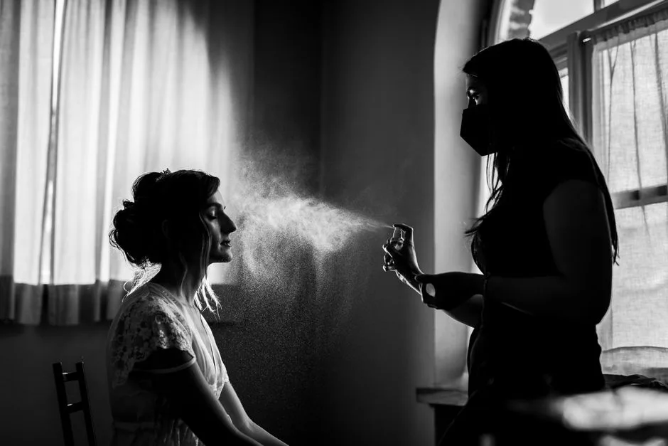 Artistic black and white photo of a beautician spraying mist in a beauty spa