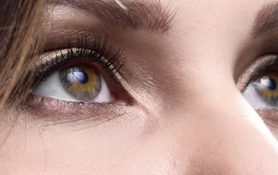 Detailed close-up of a woman's eyes with makeup, looking upwards.