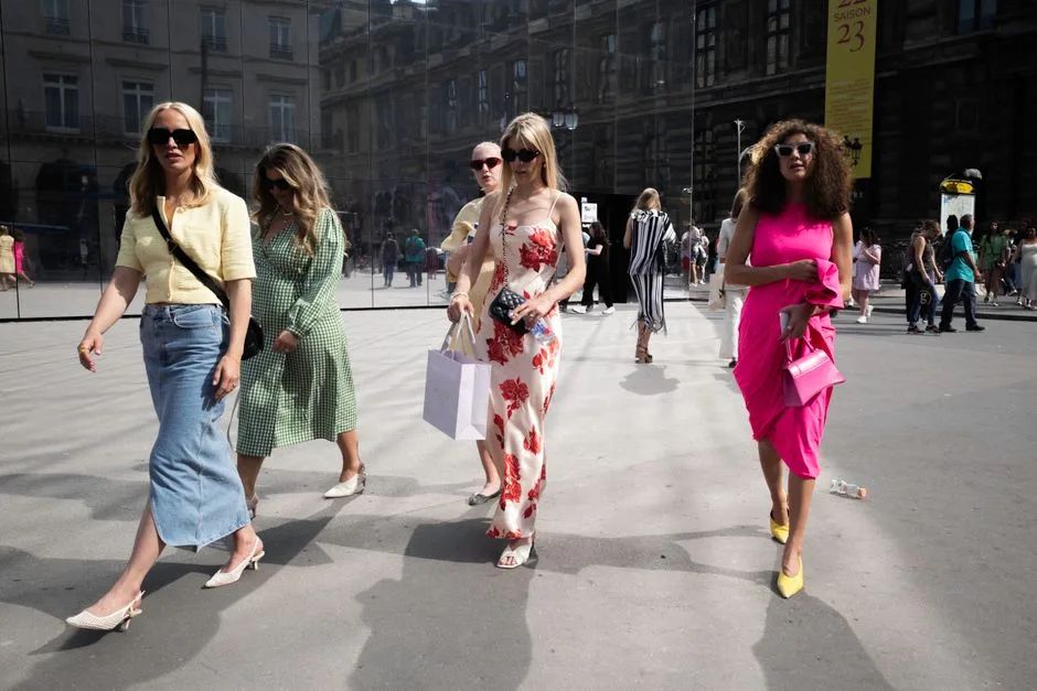 Group of stylish women walking in the city showcasing vibrant summer fashion.