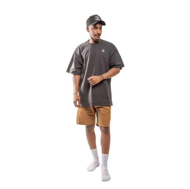 Full-body view of a man wearing casual streetwear with an oversized t-shirt and cap.