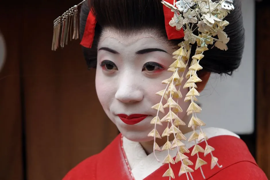 Close-up portrait of a traditional Japanese geisha in vibrant attire, Kyoto.