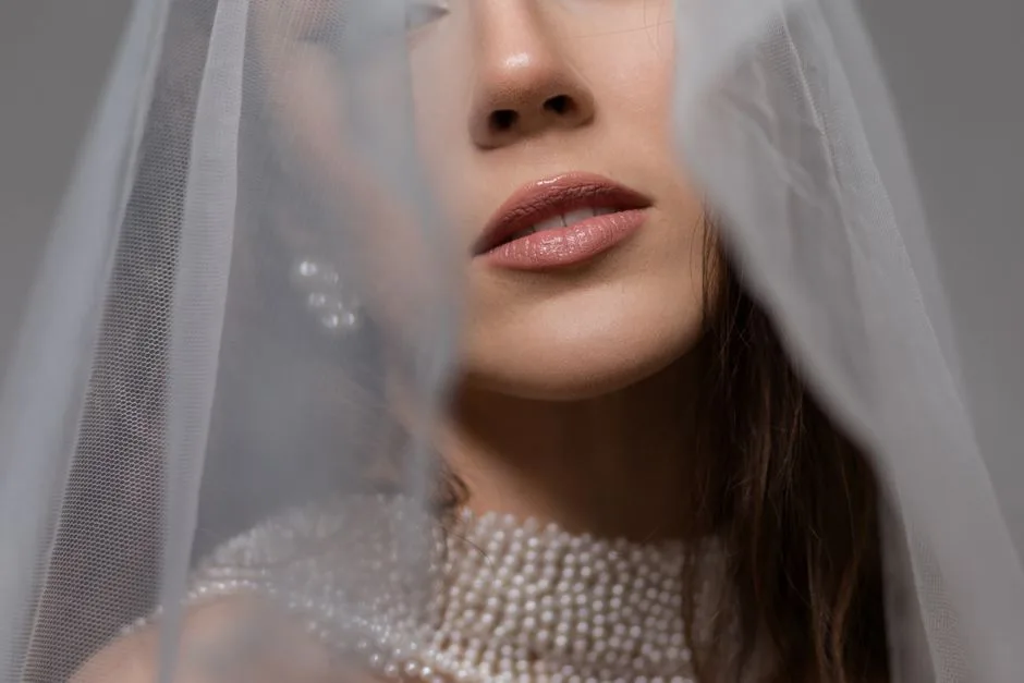Close-up of a bride with veil and pearls, showcasing elegance and beauty.