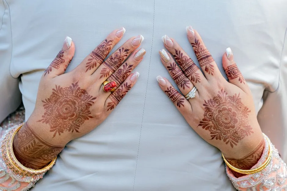 Beautiful henna designs on hands adorned with elegant jewelry, perfect for weddings.