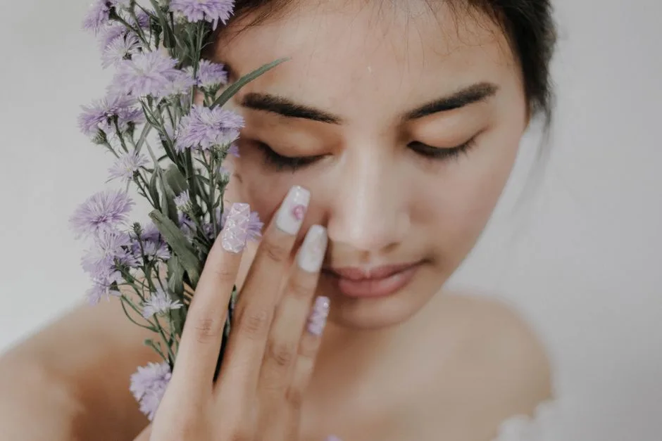 Close-up of a woman posing with purple flowers, showcasing beauty and elegance in Bali.