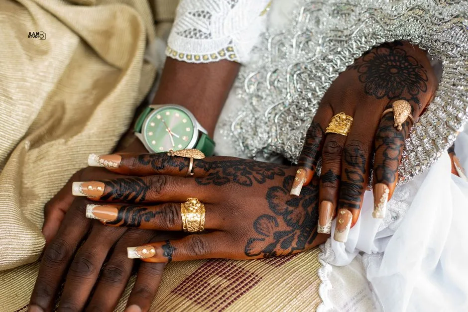 Close-up of henna-decorated hands with elaborate jewelry, showcasing cultural artistry.