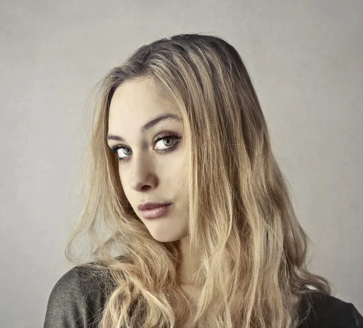 Close-up portrait of a young woman with blonde hair and captivating eyes.