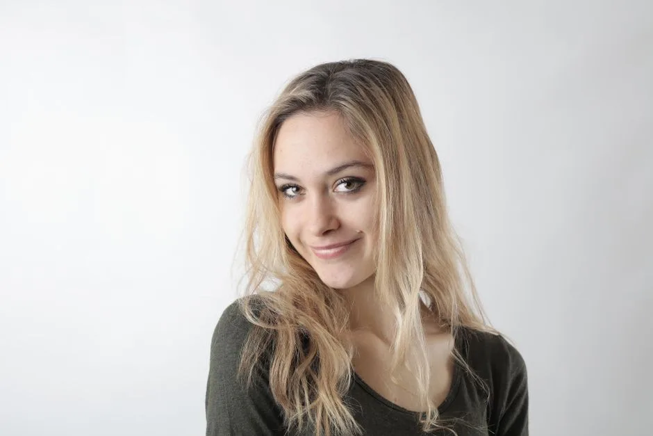 Portrait of a smiling woman with blonde hair on a white background.