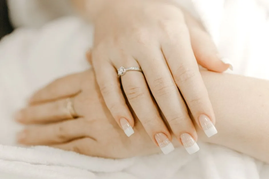 From above of hands of crop anonymous woman with classic manicure and ring with precious stone on wedding day