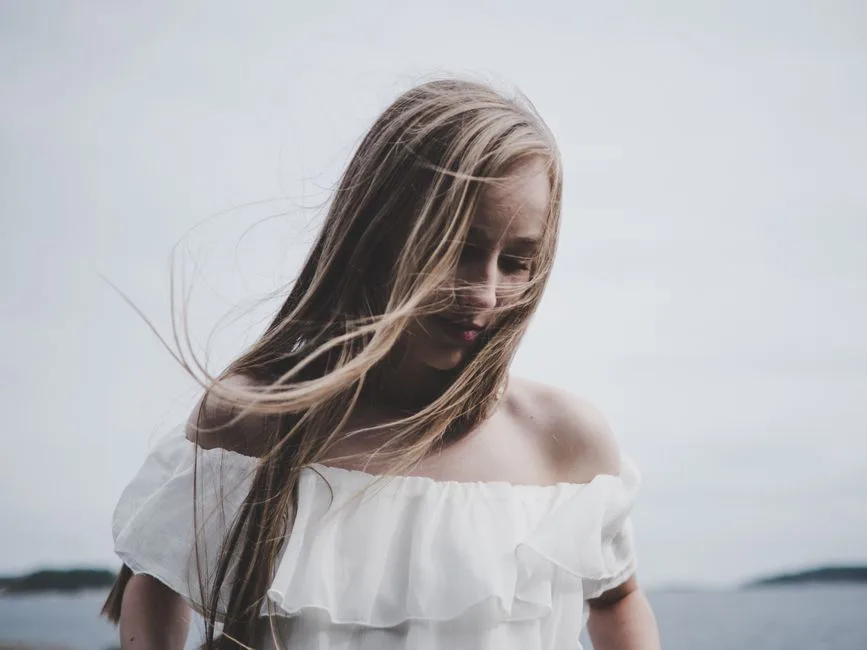 A serene portrait of a woman outdoors in soft natural light, evoking a peaceful mood.