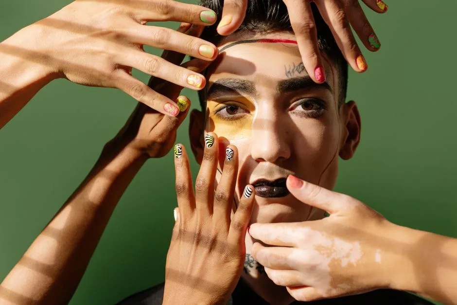Artistic portrait showcasing bold makeup, colorful nails, and diverse hands on a green background.