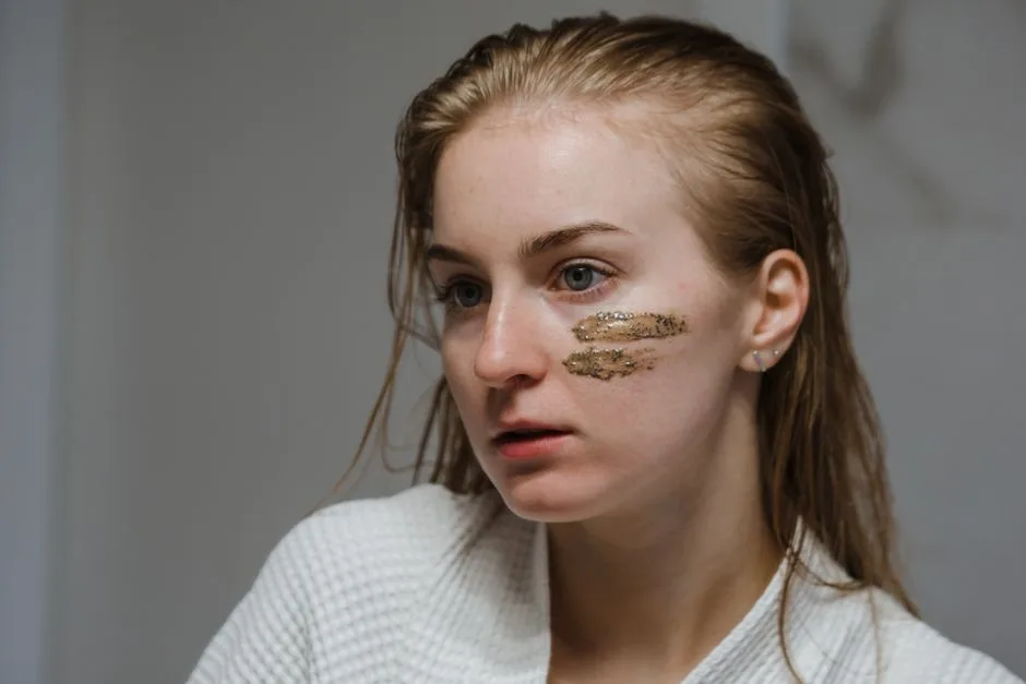 Young woman applies coffee scrub on her face for a refreshing skincare routine.