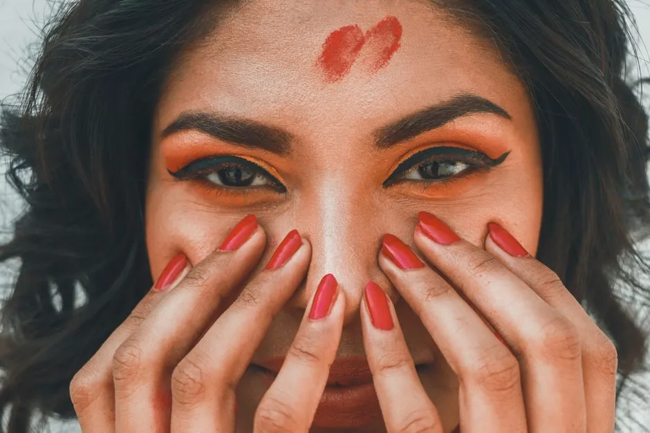 Intimate close-up of a woman in India showcasing colorful makeup and nail art.