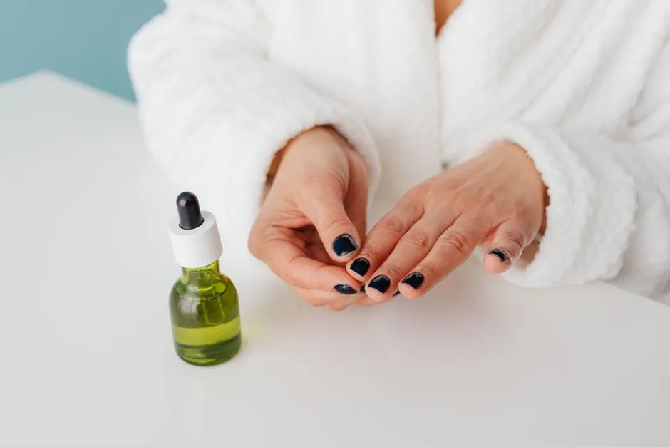 Female in a bathrobe applying serum using a green glass bottle, showcasing self-care routine.