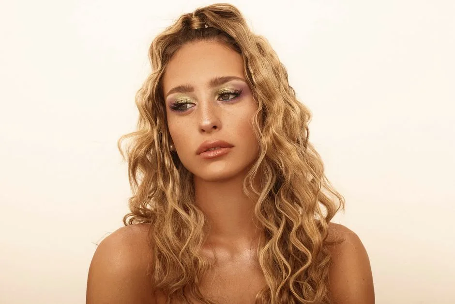 Stylish portrait featuring a woman with blonde curly hair and glamorous makeup