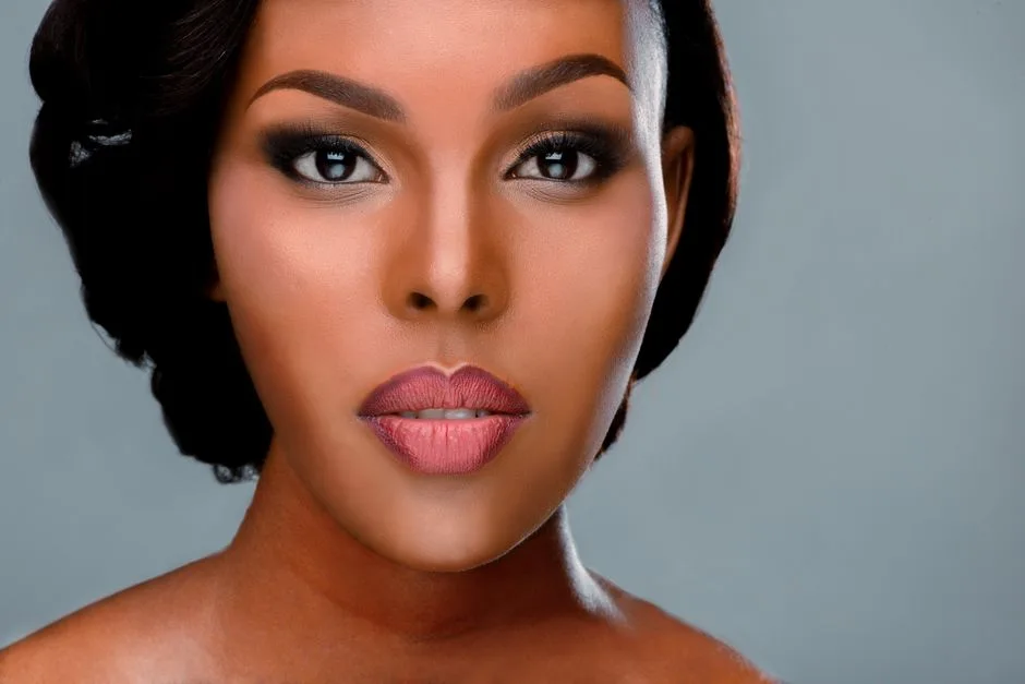 Close-up portrait of a woman with perfect makeup and expressive eyes on a smooth background.