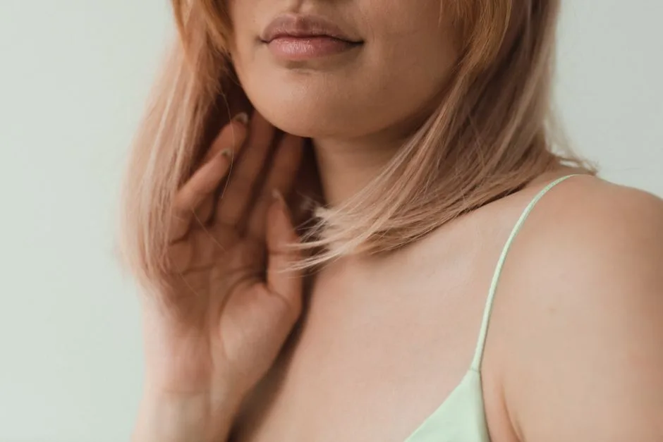 Close-up portrait of a woman with blonde hair and spaghetti strap top, highlighting soft, natural beauty.
