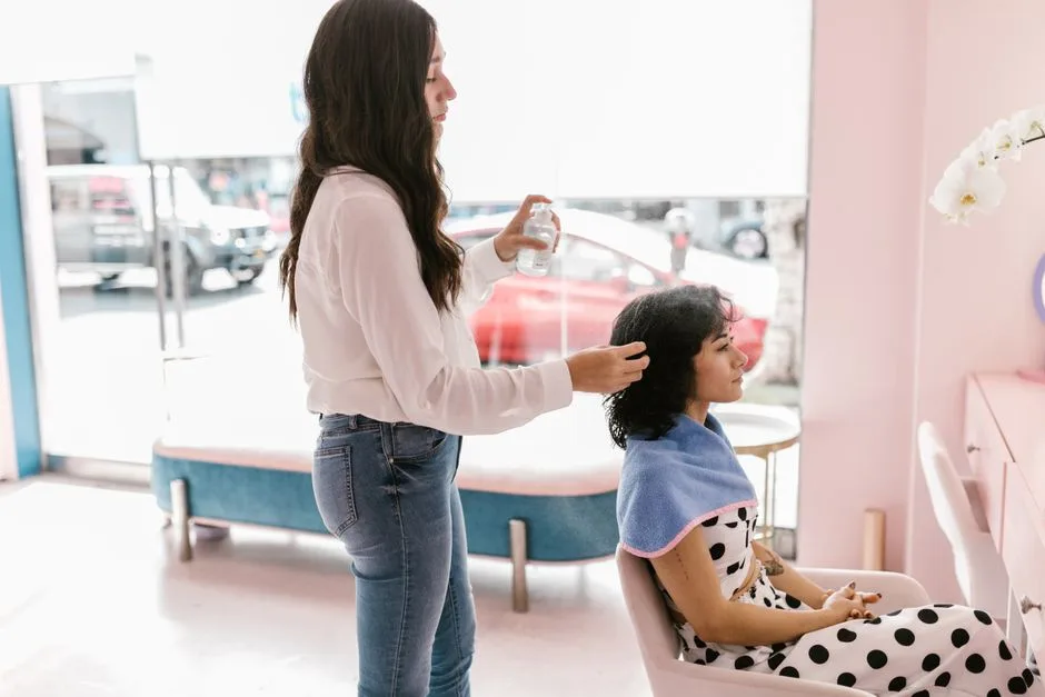 Hairdresser providing professional care to a woman in a chic salon setting. Relaxed and stylish atmosphere.