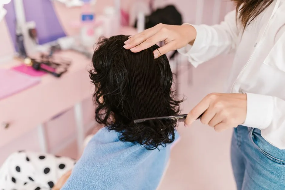 Close-up of a woman receiving hairstyling treatment in a contemporary salon.