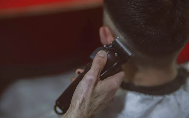Close-up view of a man getting a haircut with clippers, highlighting the precise technique.