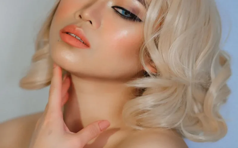 A captivating studio portrait of a blonde woman with glamorous makeup and elegant style.