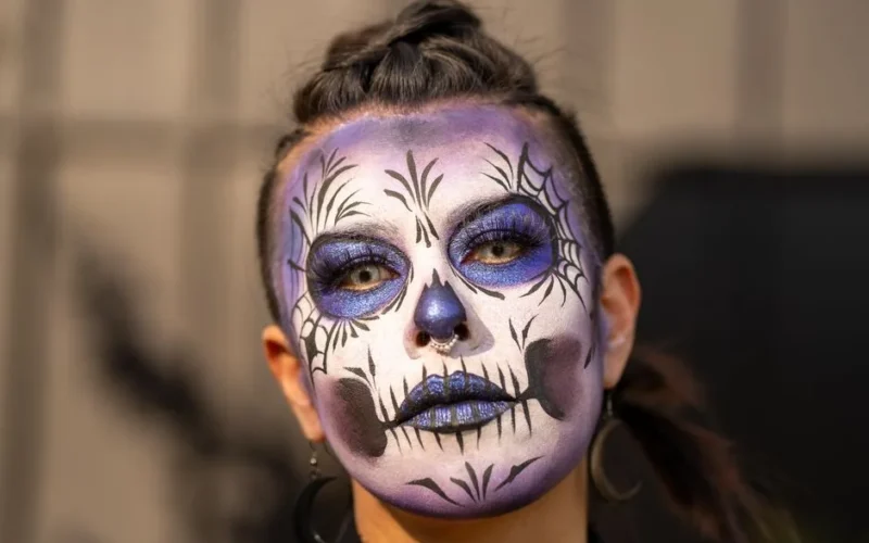 Close-up of a person wearing artistic Catrina makeup in Mexico City.