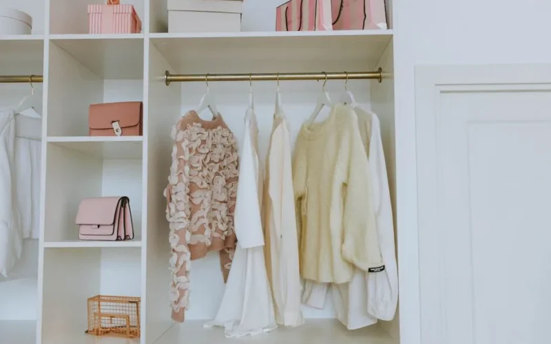 Neat closet showcasing white and pink clothes and accessories for a chic, clean look.
