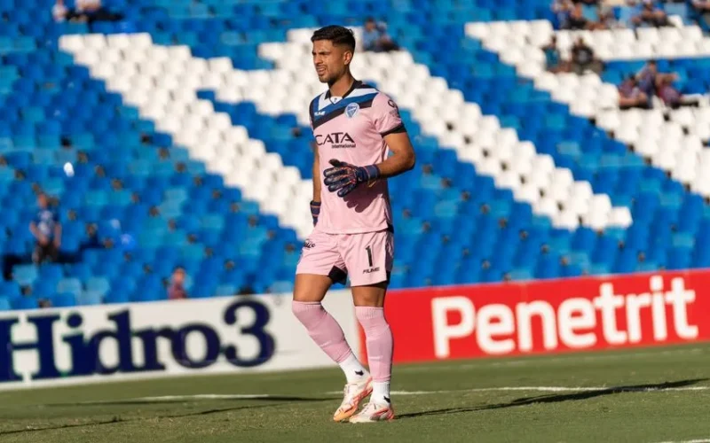 Goalkeeper wearing pink kit on the soccer field during a match.