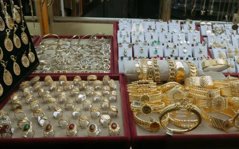 Showcase of elegant gold and silver jewelry in an Istanbul market's display case.