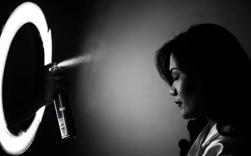 Stylish black and white portrait of a woman with dramatic lighting and spray effect.