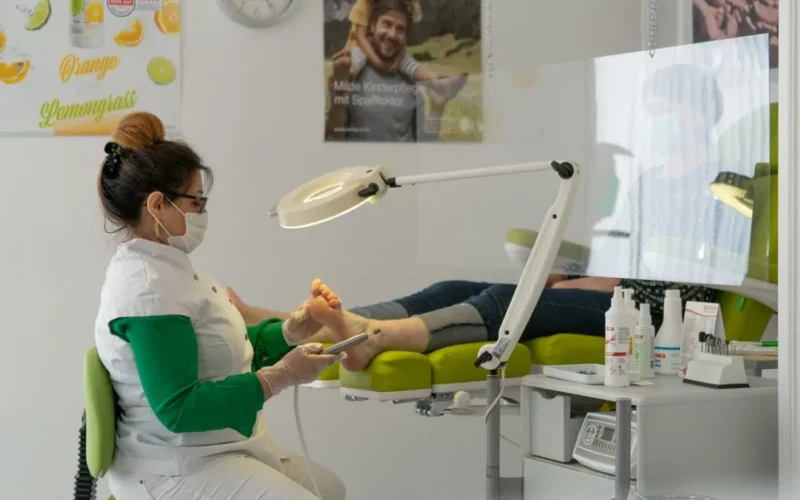 A podiatrist provides foot care to a patient in a clinical setting.