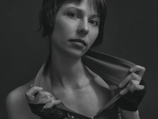 Stylish black and white portrait of a woman with short hair posing confidently.