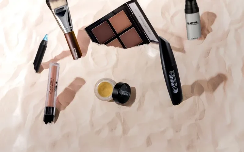 A collection of makeup products displayed stylishly on a textured surface, perfect for beauty themes.