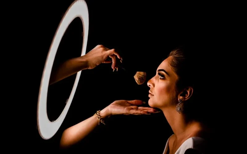 Elegant makeup application in a studio setting with professional lighting.