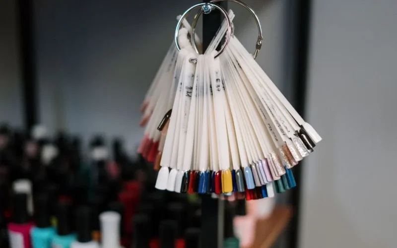 A vibrant display of nail polish swatches hanging in a beauty salon, showcasing diverse color options for manicure trends.