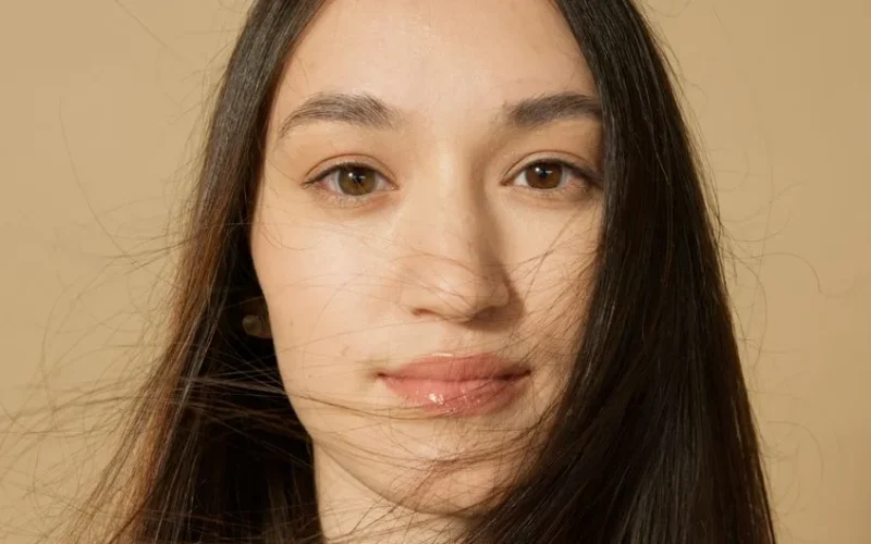 Detailed and intimate close-up portrait of a woman with long hair and a serene expression.